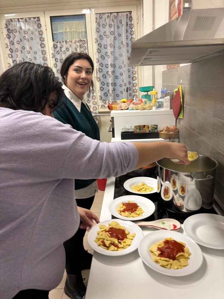 Ragazzi e volontari preparano la pasta nella cucina del Centro
