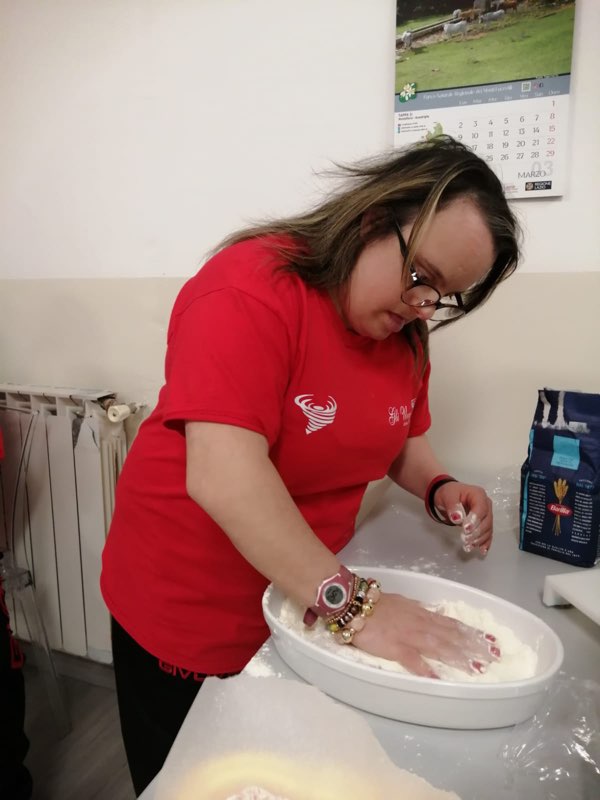 Una ragazza impasta durante il laboratorio di cucina