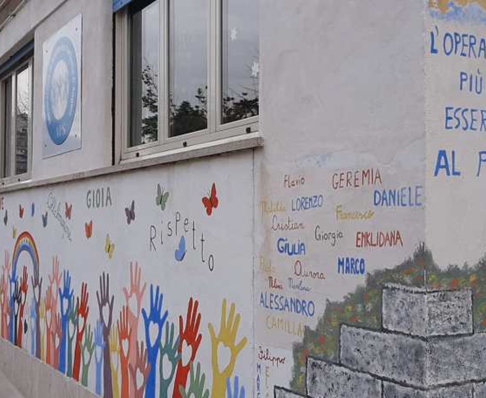 Il murale colorato con le mani e i nomi dei ragazzi sulla facciata del Centro