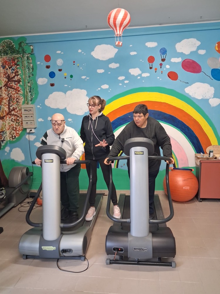 Attività motoria nella sala con il murale dell'arcobaleno